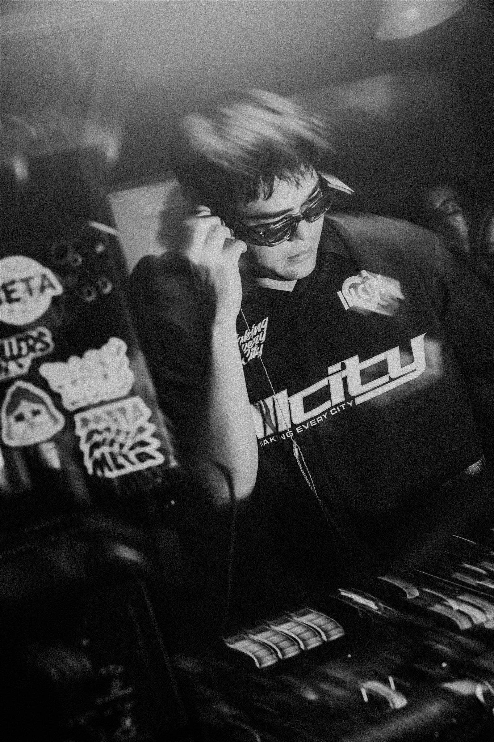 SPILLERS listening through one headphone while working at the DJ booth